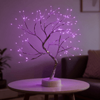 Veilleuse arbre lumineux bonsaï en lumière rose violacé, posée sur une table basse dans un salon